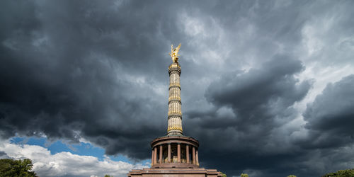 Low angle view of monument against stormy clouds