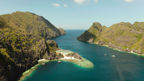 Tropical lagoon with sandy beach surrounded by cliffs, aerial view. el nido, philippines, palawan. 