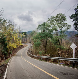 Road amidst trees against sky