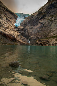 Scenic view of rocks on shore against sky