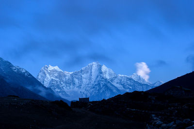 Scenic view of snowcapped mountains against blue sky