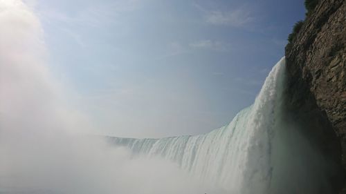 Low angle view of waterfall against sky