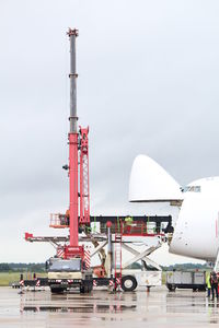 Cranes at airport against sky