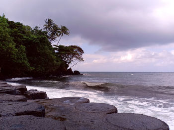 Scenic view of rocks on beach against sky