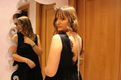 Close-up of a woman standing against wall