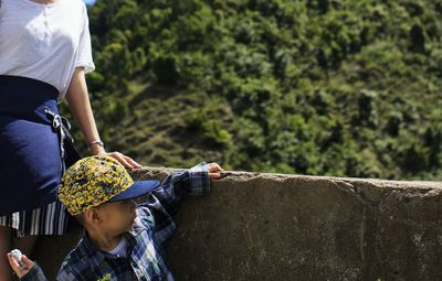 Boy throwing stone by wall