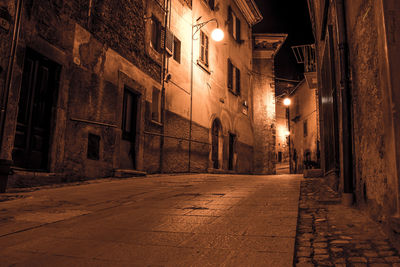 Street amidst illuminated buildings at night