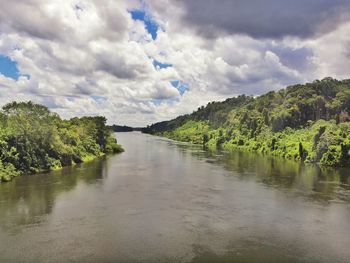 Scenic view of river against cloudy sky