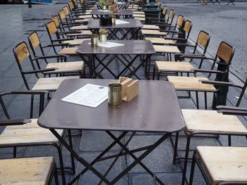 High angle view of empty chairs and tables at sidewalk cafe