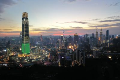 Illuminated city buildings against sky