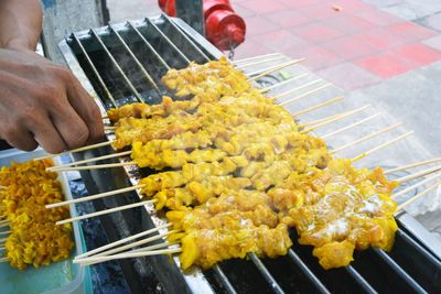 Close-up of person preparing food on barbecue grill