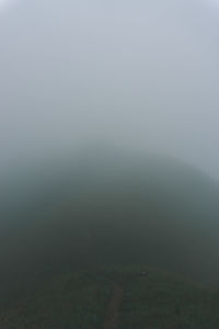 Scenic view of landscape against sky at foggy weather