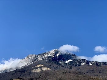 Scenic view of snowcapped mountains against blue sky