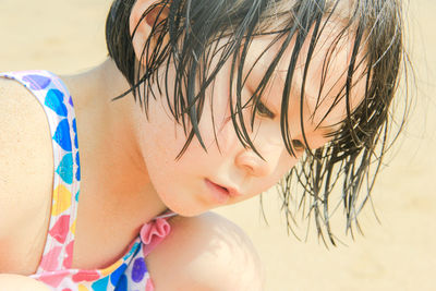 Close-up portrait of cute baby girl on beach