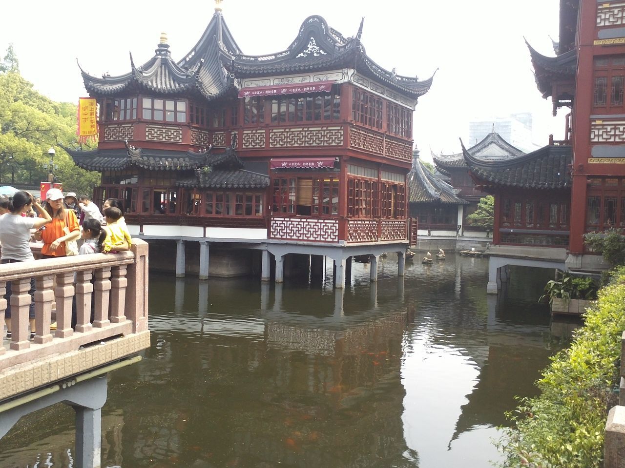 architecture, built structure, building exterior, water, reflection, waterfront, tree, place of worship, travel destinations, pond, clear sky, sky, canal, river, incidental people, famous place, outdoors, city, religion, building