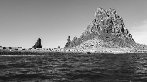 Black and white photo of sea against beach and cliff in antarctica