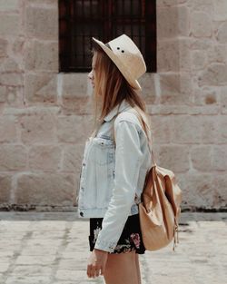 Rear view of woman standing against wall