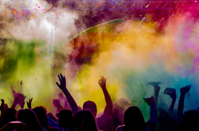 Group of people at music festival amidst powder paint