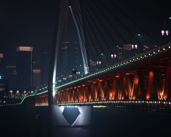 Illuminated bridge over river at night