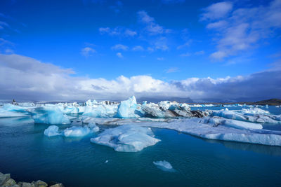 Snow covered landscape against blue sky