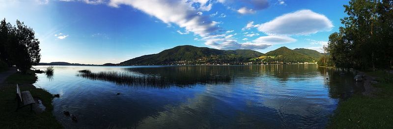 Scenic view of lake by mountains against sky