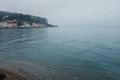 Scenic view of sea by city against clear sky