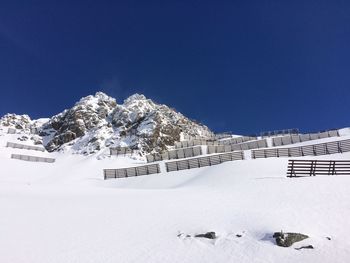 Scenic view of snowcapped mountains against clear blue sky