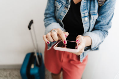 Backpacker caucasian woman at train station using smart phone app while waiting. travel concept