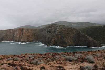 Scenic view of sea and mountains against sky