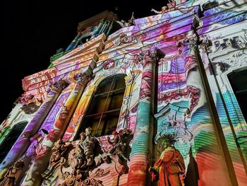 Low angle view of illuminated statue against building at night