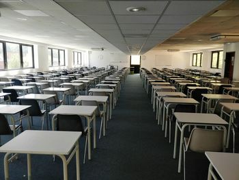 Empty chairs and tables in row