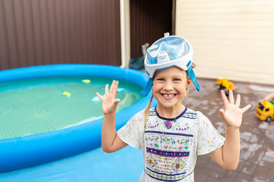 Portrait of smiling girl standing by wading pool