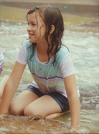 Portrait of smiling girl sitting at beach