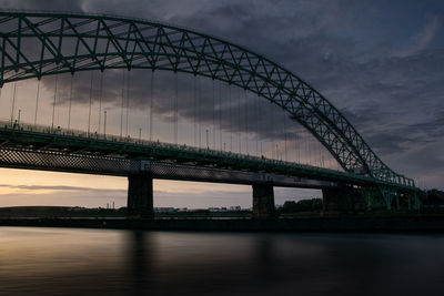 View of bridge over river against cloudy sky