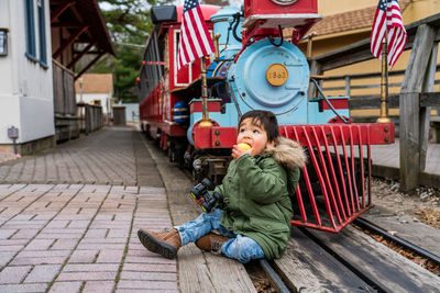 Full length of boy sitting outdoors