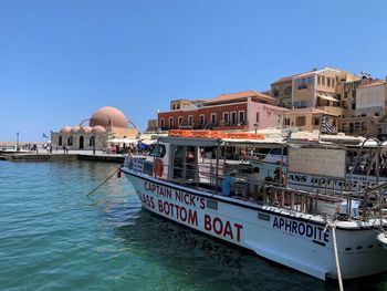 View of city by sea against clear blue sky