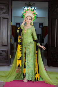 Portrait of young woman standing at home