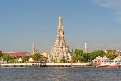 View of temple by building against sky