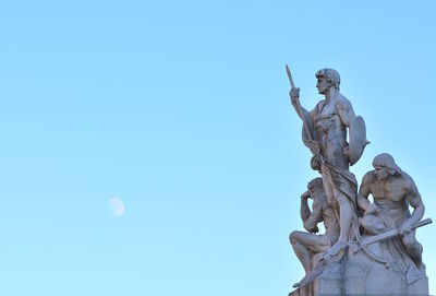 Low angle view of angel statue against clear blue sky