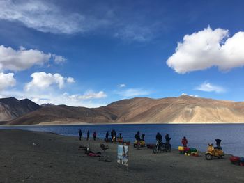 People at beach against sky