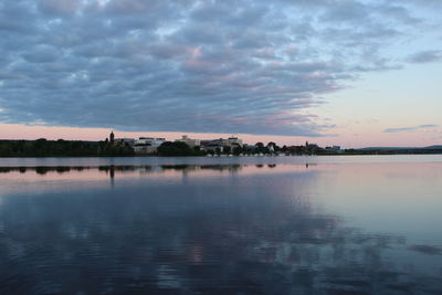 Scenic view of sea against cloudy sky at sunset