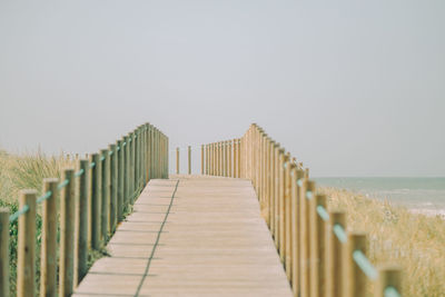 Wooden posts on beach against clear sky