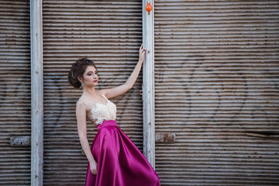 Portrait of woman standing against wall