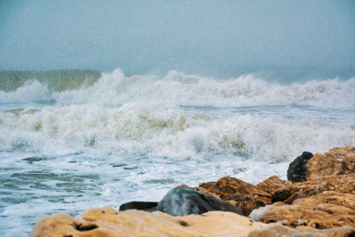 Scenic view of rocks in sea against sky