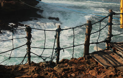 High angle view of man standing on railing against sea