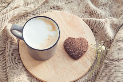 Chocolate sweets on wooden dish and cup of coffee, valentine's day breakfast