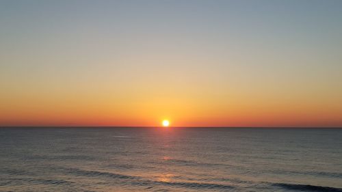 Scenic view of sea against orange sky