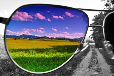 Scenic view of field against sky seen through side-view mirror