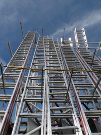 Low angle view of ladders against blue sky