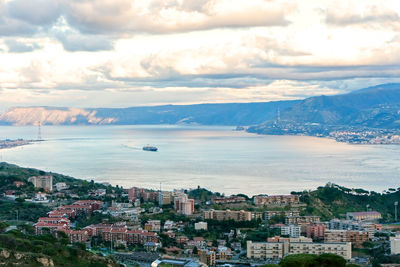 High angle view of townscape by sea against sky